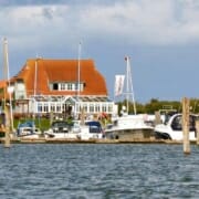 Yachthafen von Langeoog mit Booten und einem Deich mit Restaurant