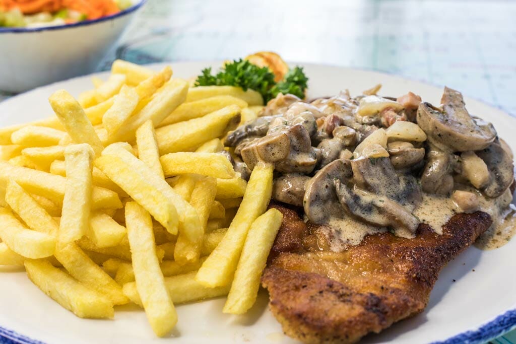 Jägerschnitzel mit Pommes auf einem Teller